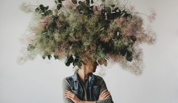 Large decorative bouquet made green leaves moss hangs man s head